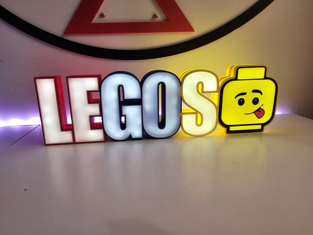 Lettrage lumineux multicolore « LEGOS » avec une tête de figurine jaune