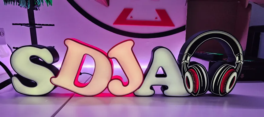 Lettrage lumineux « SDJA » avec un casque audio, éclairage rose